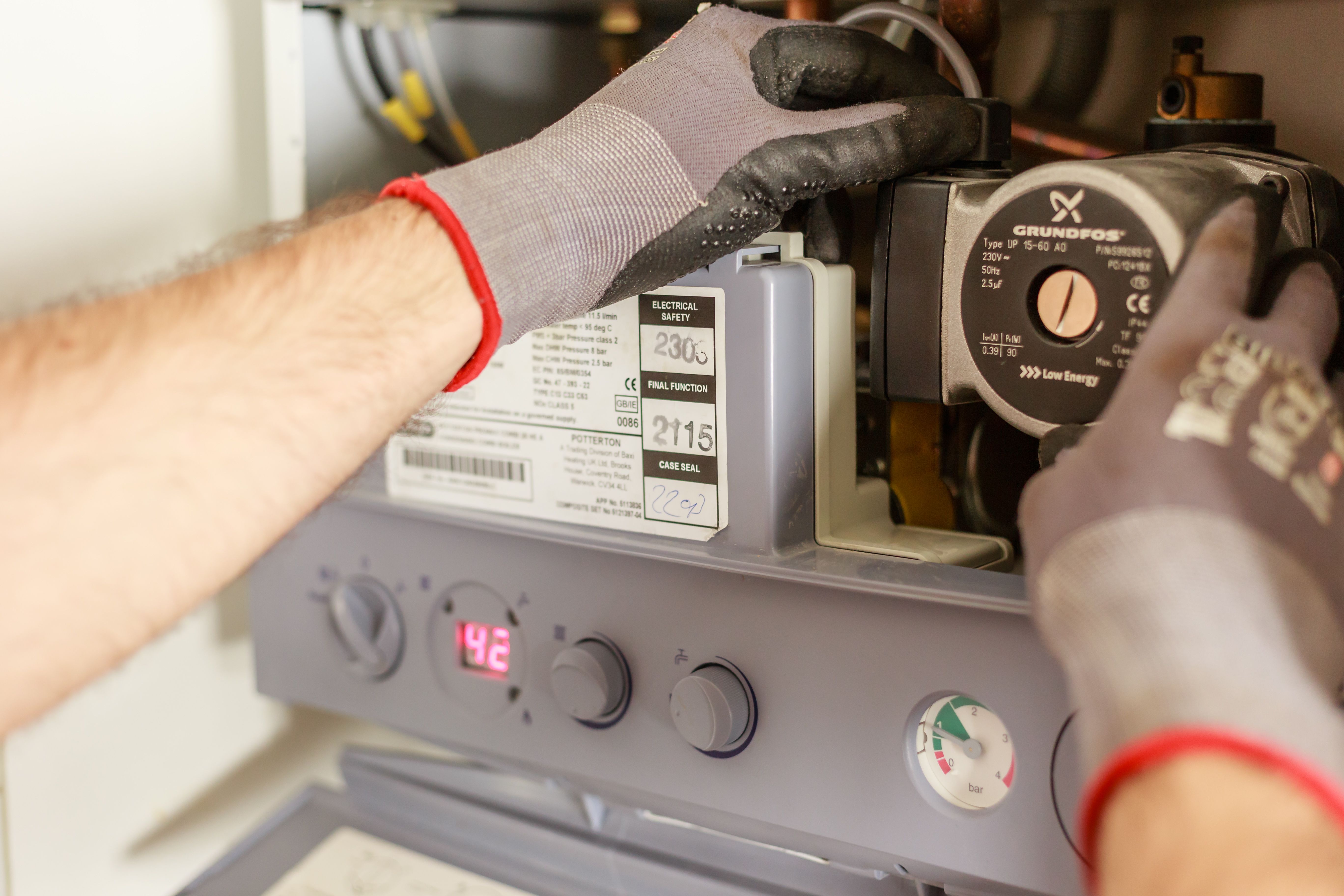 Technician using a multimeter to test a water heater thermostat