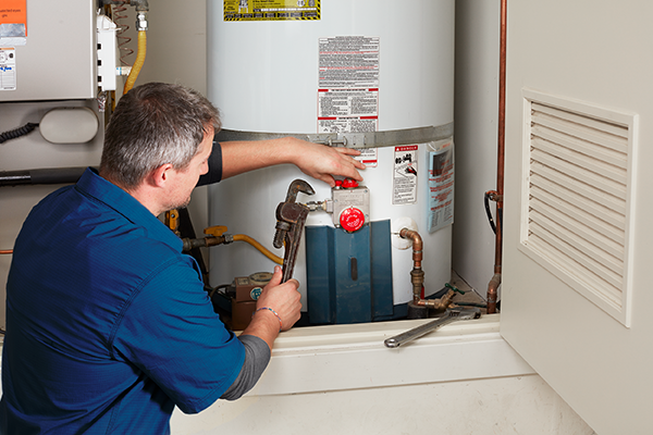 Technician installing a new water heater tank in a Cincinnati basement